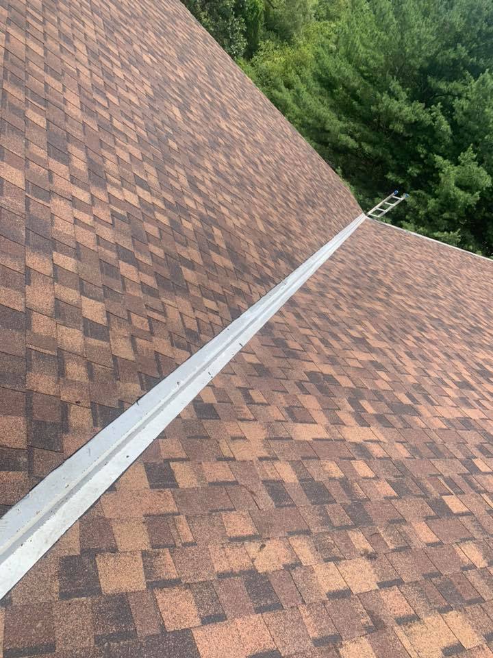 Installing brown asphalt shingles on slanted roof finished