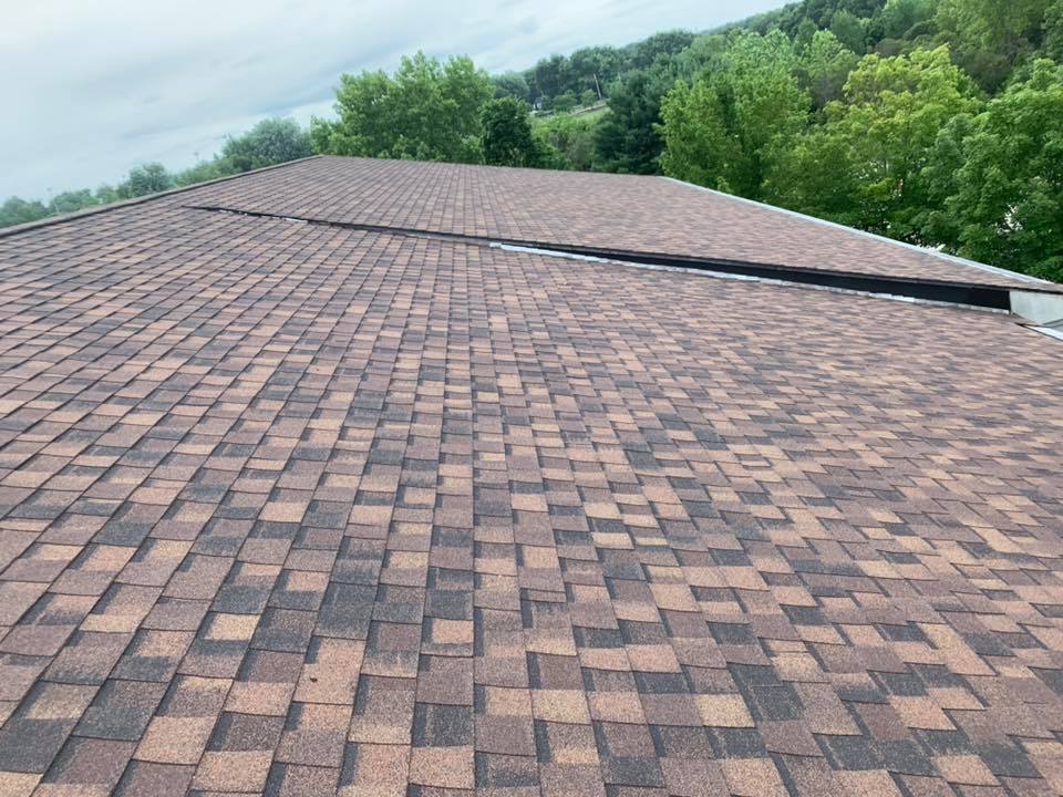 Installing brown asphalt shingles on slanted roof finished