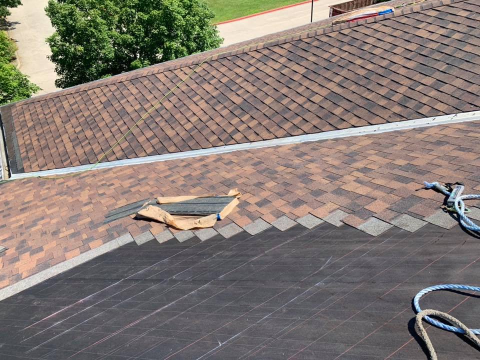 Installing brown asphalt shingles on round roof process
