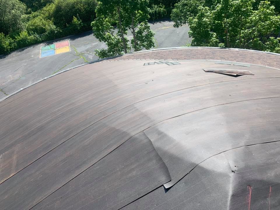 Circular roof prepped for new brown asphalt shingles