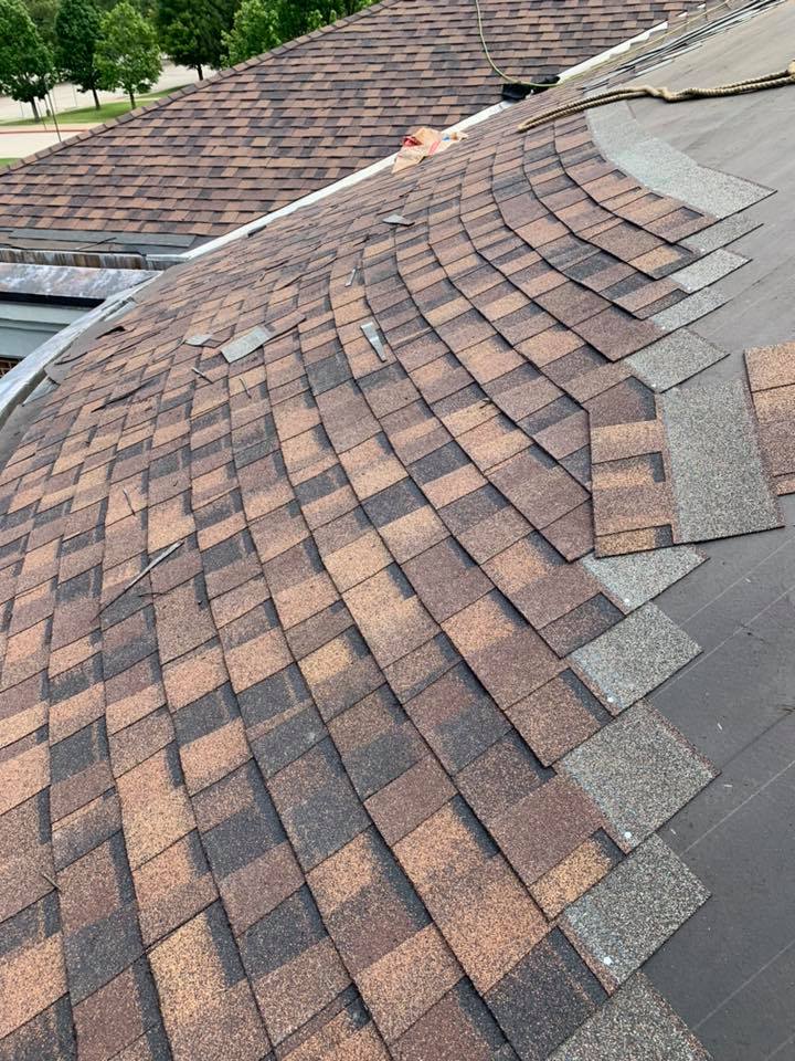 Installing brown asphalt shingles on round roof process